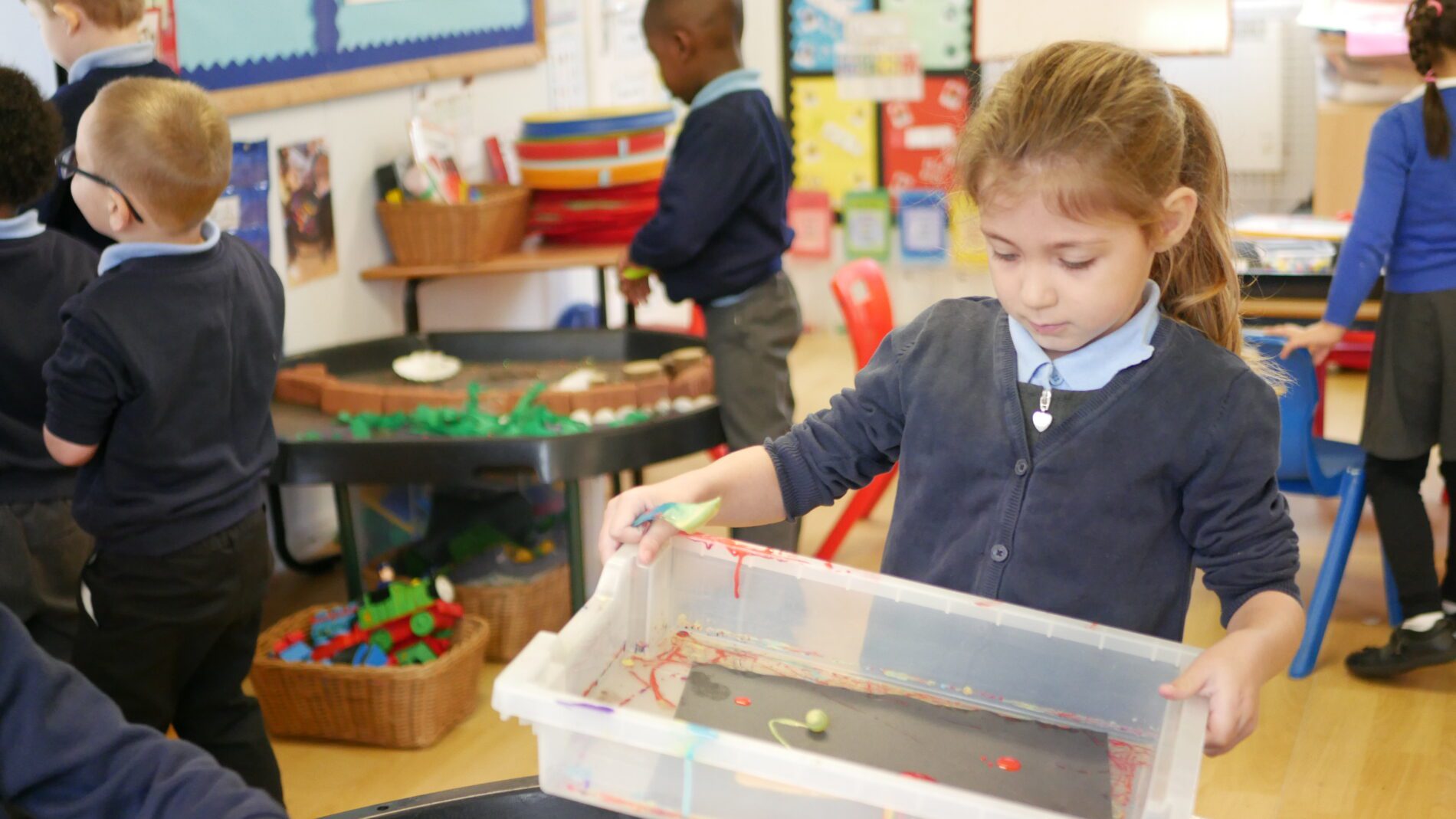 child using messy paint trays in art at rosherville cofe academy